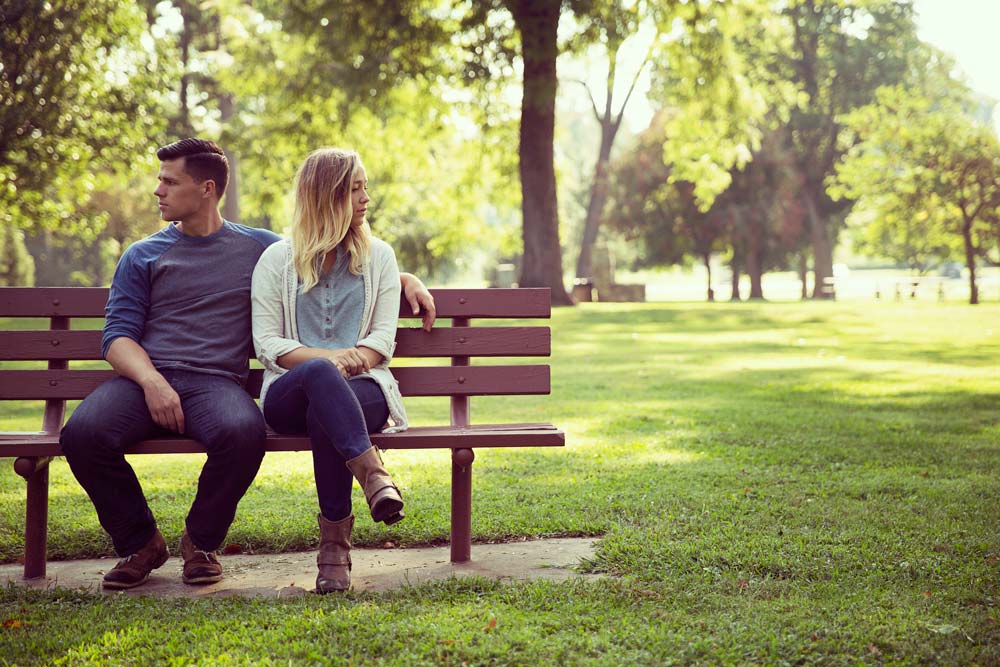 Couple on bench looking opposite ways