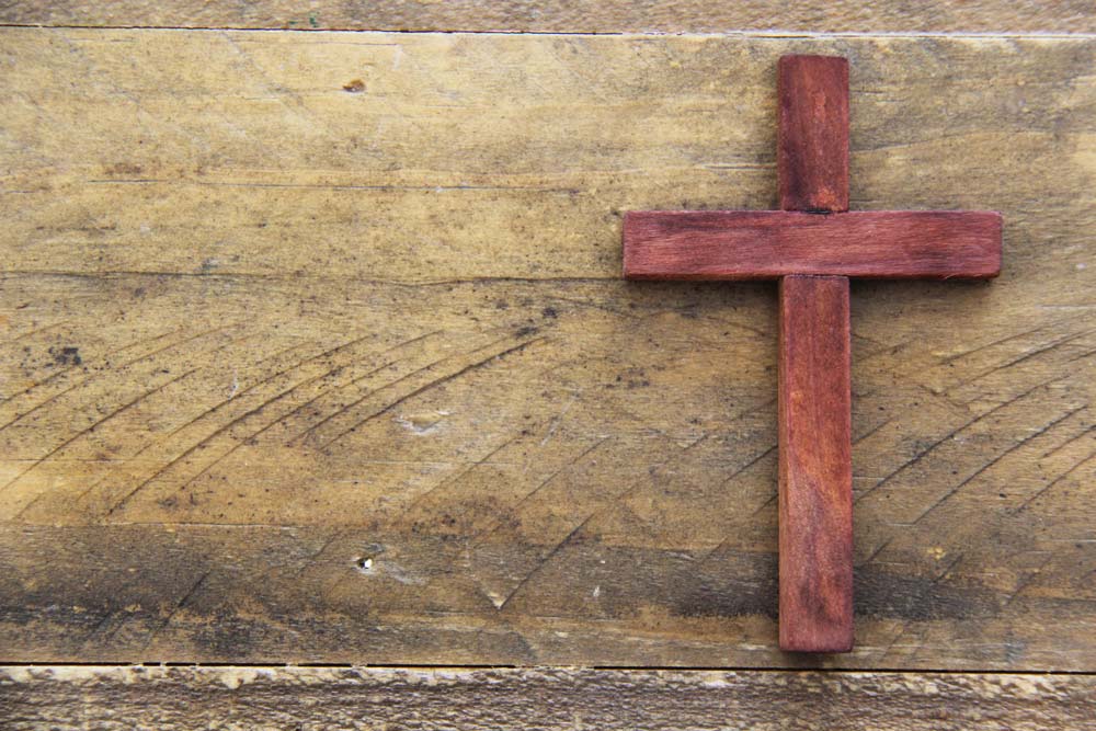 Wooden cross on wood background