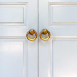 Close view of handles on white wardrobe doors
